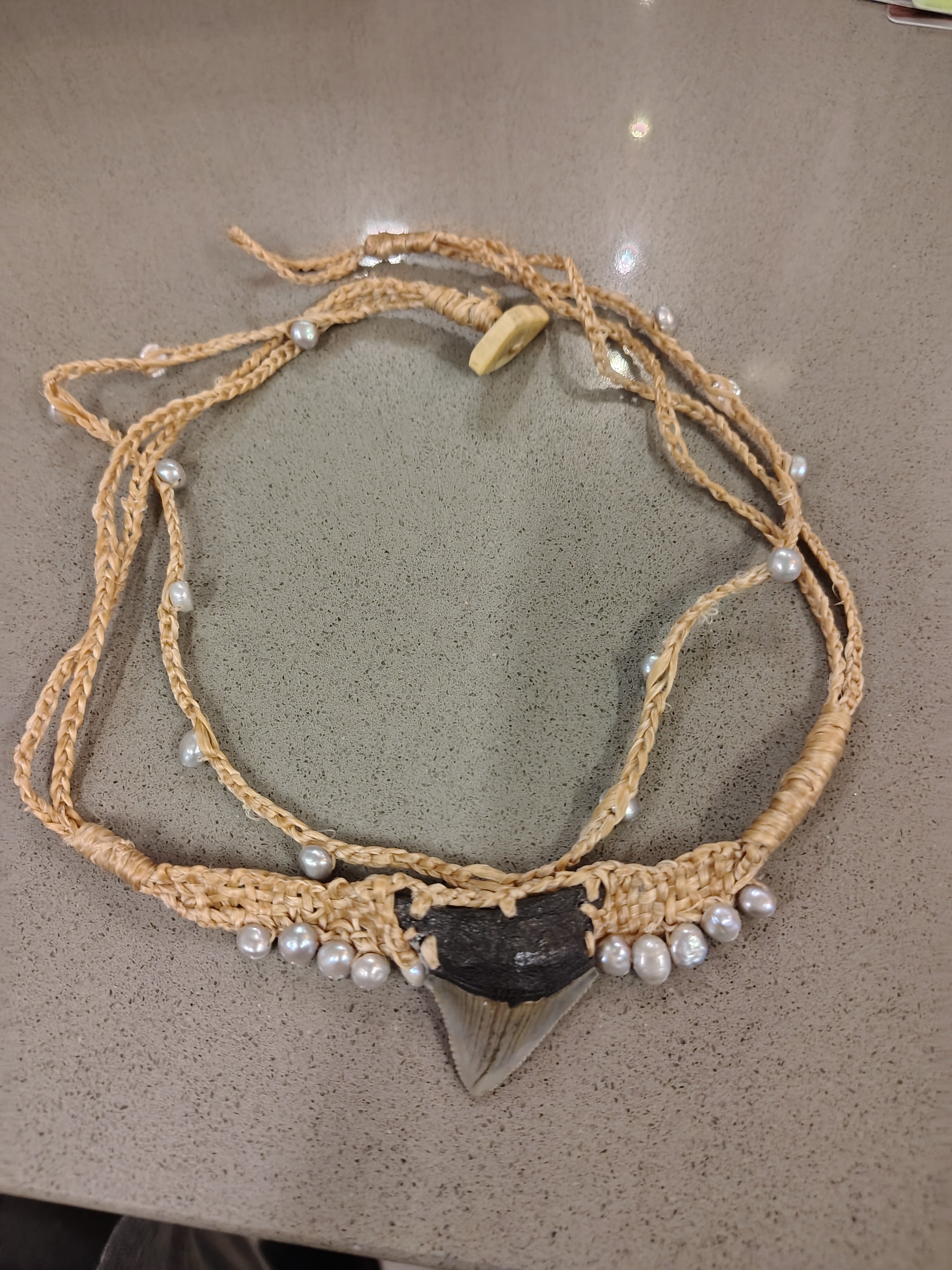 Megalodon shark tooth with fresh water.Pearls , fashioned with sinew to strands , can be worn as necklace or bracelet